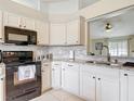 Bright kitchen with white cabinetry, granite countertops, and stainless steel appliances at 970 Courtland Blvd, Deltona, FL 32738