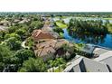 Expansive aerial view showcases the property with its tile roof, a serene lake, and beautifully landscaped surroundings at 1070 Henley Downs Pl, Lake Mary, FL 32746