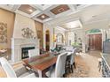 Elegant dining room with a stone fireplace, decorative ceiling, and an open layout to the living spaces at 1070 Henley Downs Pl, Lake Mary, FL 32746