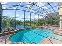 Inviting screened-in pool and spa area overlooking a peaceful lake, perfect for relaxation and entertaining at 1070 Henley Downs Pl, Lake Mary, FL 32746