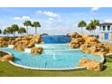 Beautiful cascading water feature on manicured grounds with palm trees and blue skies. This feature welcomes you to the community at 11182 Hollow Bay Dr, Winter Garden, FL 34787