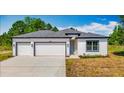 Charming single-story home with a three-car garage, neutral paint, and well-manicured lawn at 12885 Sw 43, Ocala, FL 34473