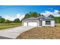 Charming single-story home with a three-car garage, neutral paint, and well-manicured lawn at 12885 Sw 43, Ocala, FL 34473
