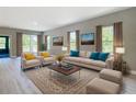 Bright living room featuring stylish furniture, neutral color scheme, and natural light from large windows at 12885 Sw 43, Ocala, FL 34473