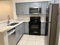 Charming kitchen showcasing gray cabinets, stainless appliances, and ample counter space at 14001 Fairway Island Dr # 525, Orlando, FL 32837
