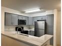 Well-lit kitchen featuring modern gray cabinets, new appliances, and white countertops at 14001 Fairway Island Dr # 525, Orlando, FL 32837