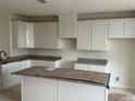 Spacious kitchen with white cabinets, granite countertops, and a center island awaiting your personal touch at 15089 Grove Lake Dr, Winter Garden, FL 34787