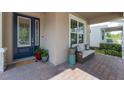Inviting front porch featuring comfortable seating, plants, decorative pillows, and brick flooring at 15420 Southern Martin St, Winter Garden, FL 34787