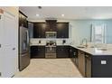 Modern kitchen featuring stainless steel appliances and dark wood cabinetry at 1575 Plunker Dr, Davenport, FL 33896