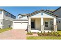 Charming single-story home featuring a spacious two-car garage and inviting covered front porch with stone accents at 16103 Silver Brook Way, Winter Garden, FL 34787