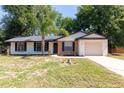 Inviting home exterior featuring a well-manicured lawn and a two-car garage at 18 Palmira Rd, Debary, FL 32713