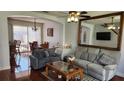 Inviting living room boasts stylish couches, coffee table, and mirror, seamlessly flowing into the adjacent dining area at 2157 Island Walk Dr, Orlando, FL 32824