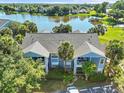 Lakefront condominium complex with mature trees and landscaping, offering serene views and a peaceful community at 2501 Grassy Point Dr # 103, Lake Mary, FL 32746