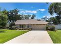 Charming one-story home features a well-manicured lawn, mature trees, and a neutral exterior color scheme at 3300 Se 22Nd Ave, Ocala, FL 34471
