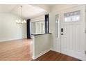 Bright foyer with hardwood floors and white trim showcases a modern entry door and elegant chandelier at 3300 Se 22Nd Ave, Ocala, FL 34471