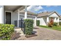 A well kept home featuring a paved driveway leading to a two-car garage and landscaped greenery at 338 Wooded Vine Dr, Winter Springs, FL 32708