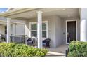 Comfortable covered front porch with seating and manicured landscaping leading to the front door at 338 Wooded Vine Dr, Winter Springs, FL 32708