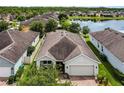 Aerial view of a single-story home with a well-maintained roof and landscaping near a serene lake at 4051 Prairie Reserve Blvd, Orlando, FL 32824