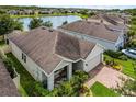 Aerial of a single-story home featuring a lanai and lush landscaping, near a picturesque lake at 4051 Prairie Reserve Blvd, Orlando, FL 32824
