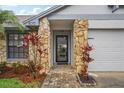 Inviting front entryway with stone accents, landscaping, and a brick-paved walkway at 520 Starstone Dr, Lake Mary, FL 32746