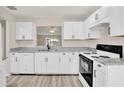 Bright kitchen featuring white cabinets, granite countertops, and stainless appliances at 600 Northern Way # 103, Winter Springs, FL 32708
