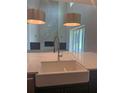 Kitchen view shows a large sink, stainless steel faucet, pendant lighting, and living room at 6125 Village Edge Pl, Sanford, FL 32771