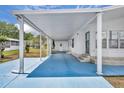 A spacious carport leads to the entrance of this charming home with a blue painted drive at 750 Polo Park Blvd, Davenport, FL 33897