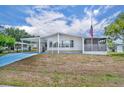 Charming single-story home featuring a carport, screened porch, and a well-maintained lawn under a sunny sky at 750 Polo Park Blvd, Davenport, FL 33897
