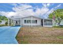 Charming single-story home featuring a carport, screened porch, and a well-maintained lawn under a sunny sky at 750 Polo Park Blvd, Davenport, FL 33897