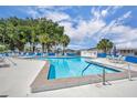 Community pool surrounded by lounge chairs and tables, perfect for relaxation and recreation at 750 Polo Park Blvd, Davenport, FL 33897