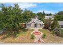 An aerial view of a home showing its charming landscape, a decorative fountain feature, and surrounding trees at 803 Jersey Ave, St Cloud, FL 34769