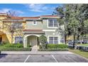 Charming two-story townhome with a well-maintained lawn, neat shrubbery, and a decorative tile roof at 8919 Bismarck Palm Rd, Kissimmee, FL 34747