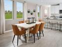 Bright dining room with large windows, modern decor, and seamlessly connected to the kitchen at 911 Donahue Pass, Lake Hamilton, FL 33851