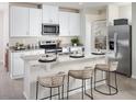 Modern kitchen with white cabinets, granite countertops, stainless steel appliances, and a breakfast bar at 911 Donahue Pass, Lake Hamilton, FL 33851