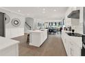 Modern open-concept kitchen with white cabinetry, an island, and wood flooring at 11057 Hollow Bay Dr, Winter Garden, FL 34787