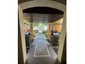 Framed view from inside a building entryway, showing a walkway and landscaping beyond at 12527 Floridays Resort Dr # 506-E, Orlando, FL 32821