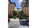 Exterior view of the building showcasing its architectural design, landscaping, and parking at 12527 Floridays Resort Dr # 506-E, Orlando, FL 32821