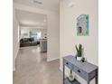 Inviting hallway with console table, art and ceramic tile that leads to the living room at 1323 Berry Ln, Davenport, FL 33837