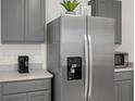 A stainless steel refrigerator and gray kitchen cabinets offer plenty of space at 1323 Berry Ln, Davenport, FL 33837