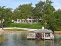 Aerial view featuring the home, lawn, lake and multi-boat boathouse with power lifts and lake access at 1455 Kelso Blvd, Windermere, FL 34786