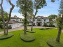 Beautiful home with manicured lawn, mature trees, and a long driveway leading to a three-car garage at 1455 Kelso Blvd, Windermere, FL 34786