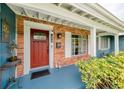 Inviting brick front porch featuring a vibrant red door, a 'Welcome' mat, and stylish exterior details at 1516 Arthur St, Orlando, FL 32804