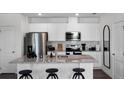 Modern kitchen featuring white cabinets, stainless steel appliances, granite countertops, and a stylish island with bar stool seating at 16341 Lakelet Aly, Winter Garden, FL 34787