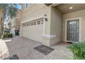 Close-up exterior showcasing the two-car garage, paved driveway, and a well-maintained front entrance with a decorative door at 2186 Tripoli Ct, Kissimmee, FL 34747