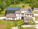 Aerial view of a luxury home with a screened pool, solar panels, and a spacious yard at 2245 Bronco Dr., St Cloud, FL 34771