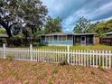 Cozy one-story home with a classic white picket fence and a relaxing screened porch at 245 S Rhodes St, Mount Dora, FL 32757
