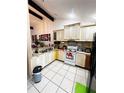 Well-lit kitchen features white cabinetry, a stainless steel refrigerator, and tile flooring for easy maintenance at 2716 Upsandown St, Orlando, FL 32837