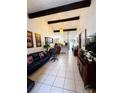 Spacious living room with beamed ceilings, tile flooring, and an open layout flowing into the dining area at 2716 Upsandown St, Orlando, FL 32837