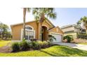 Inviting single-Gathering home with lush landscaping, a two-car garage, and an arched entryway at 2805 Lido Key Ct, Kissimmee, FL 34747