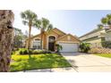 Inviting single-Gathering home with lush landscaping, a two-car garage, and an arched entryway at 2805 Lido Key Ct, Kissimmee, FL 34747